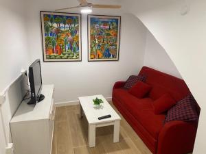 sala de estar con sofá rojo y mesa en La Casa del Castell, en Onda