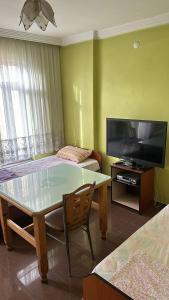 a living room with a table and a flat screen tv at S OTEL SİVAS in Sivas