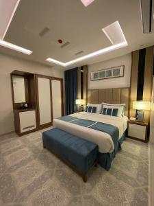 1 dormitorio con 1 cama grande con reposapiés azul en كيان ان Kian N, en Khamis Mushayt
