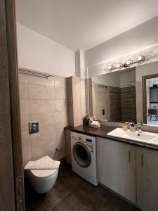 une salle de bain avec une machine à laver et un lavabo dans l'établissement Phils Apartments II, à Leucade 21 autres photos