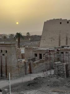 a building under construction with the moon in the background at Shahhat House in Luxor