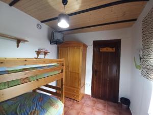 - une chambre avec des lits superposés et une télévision dans l'établissement Casita de Campo El Bujeo, à Grenade