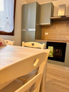 een keuken met een houten tafel met stoelen en een oven bij TuscanyAnnerelax in Cecina +11 foto's