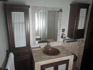 La salle de bains est pourvue d'un lavabo et d'un grand miroir. dans l'établissement Casita de Campo El Bujeo, à Grenade