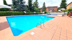 una piscina in un resort con una persona accanto di Cappuccini Appartments a Peschiera del Garda