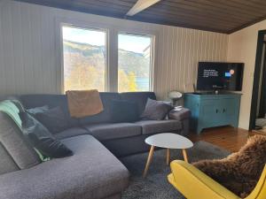 een woonkamer met een bank en een tv bij Nordfjordcabins Utvik in Utvik