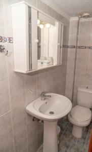 uma casa de banho com um lavatório branco e um WC. em Stella's Apartment em Alexandroupoli