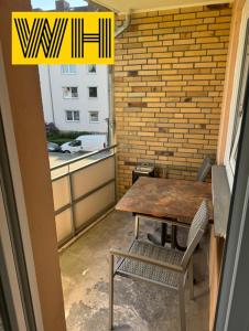 a table and chair on a balcony with a brick wall at Wohnung mit 4 Betten KÖ1 in Hannover