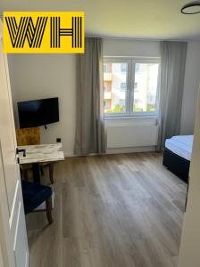 a room with a bed and a desk and a television at Wohnung mit 4 Betten KÖ1 in Hannover