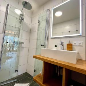 a bathroom with a sink and a shower at Chalets Zöhrer - Wohnen am Wasser in Weissensee