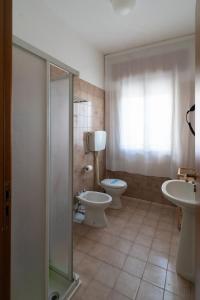 y baño con aseo, lavabo y ducha. en Residence Rex, en Chioggia