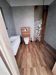 uma casa de banho com uma banheira, um lavatório e um WC. em Agroturystyka Pod Brzozami em Rychwał