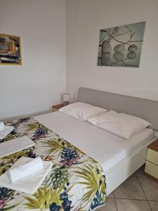 una camera da letto con un letto con copriletto bianco di Studio I a Baška