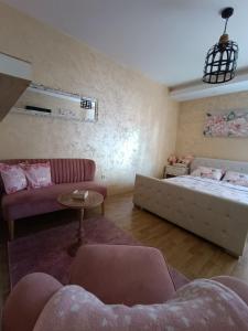 salon z łóżkiem i kanapą w obiekcie Apartman Golden Rose w mieście Loznica