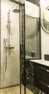a shower with a glass door in a bathroom at Apartament Ski Sudety Kowary in Kowary