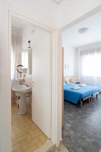 a bedroom with a bed and a bathroom with a sink at Residence Rex in Chioggia
