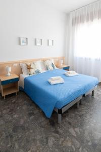 a bedroom with a blue bed with two towels on it at Residence Rex in Chioggia