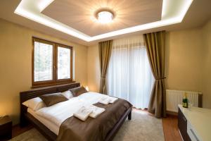 a bedroom with a large bed with two towels on it at Hotel DARO in Banská Štiavnica