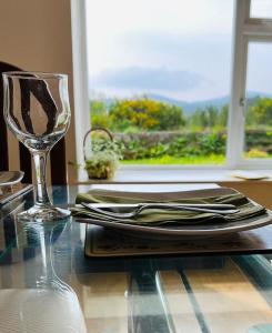 una tavola con bicchiere da vino e un tavolo con una tabella di thritistrinittis di Cosy Country House in Deeside a Finzean