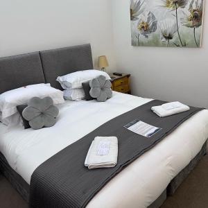 1 dormitorio con 1 cama con toallas en Tides Reach Guest House en The Mumbles