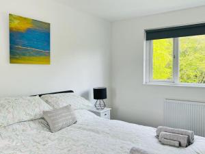 una camera bianca con un letto e una finestra di Cosy Country House in Deeside a Finzean