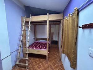 a bunk bed in a room with a ladder at El Hospedaje del Muki in Ollantaytambo