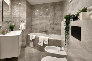 a bathroom with a tub and a toilet and a sink at SkyHotelGwarna in Legnica