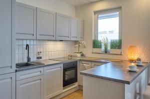a kitchen with white cabinets and a counter top at SkyHotelGwarna in Legnica