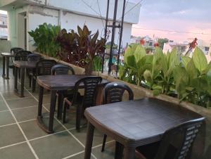 una fila de mesas y sillas en un balcón con plantas en Parijat PG, en Udaipur