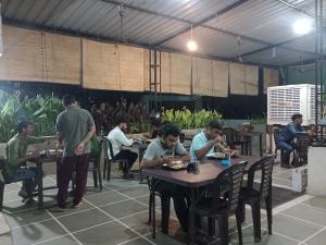 a group of men sitting at tables in a restaurant at Paarijat PG in Udaipur +45 photos