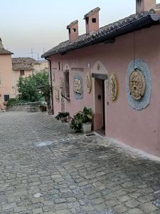 a pink building with plates on the side of it at La Corte Alta in Fossombrone