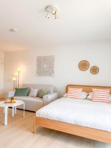 a bedroom with a bed and a couch at theSunset Club - Studio II - Küche - Balkon - Parken in Memmingen
