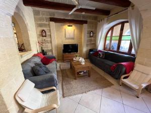 uma sala de estar com um sofá e uma televisão em Tal-Mans Farmhouse Gozo em Sannat