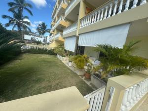 a balcony of a building with a yard with palm trees at Las Palmeras by Graziano in Boca Chica