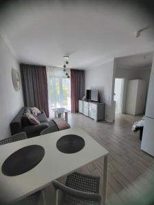 a living room with a table and a couch at Apartamenty Olimpijska in Gorzów Wielkopolski