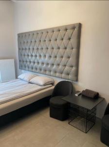 a bedroom with a bed and a chair and a table at Spanie 7-Rynek Centrum &f-vat Car park in Kielce
