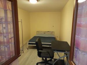 a bedroom with a bed and a chair and a mirror at Jolie longère au calme proche du Futuroscope in Saint-Georges-lès-Baillargeaux