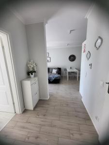 a room with a hallway with white walls and a table at Apartamenty Olimpijska in Gorzów Wielkopolski