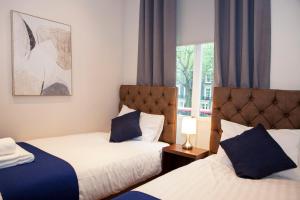1 dormitorio con 2 camas y ventana en Putera Puteri Residence, en Londres