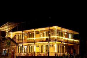 a large building with lights on it at night at Odin Hostel Jibhi in Jibhi