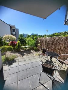 a patio with a table and chairs and a fence at Apartamenty Olimpijska in Gorzów Wielkopolski