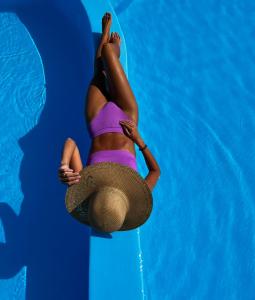 a woman laying on her back in a swimming pool at Family Villages Santorini in Vlychada Beach
