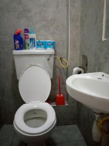 La salle de bains est pourvue de toilettes blanches et d'un lavabo. dans l'établissement Rew Apartment, à Nairobi