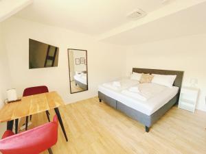 a bedroom with a bed and a table and chairs at StayHere Central City Studio 14 - contactless Self-Check-IN in Graz