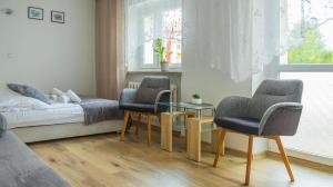 sypialnia z 2 krzesłami, stołem i łóżkiem w obiekcie Apartament Ski Sudety Kowary w mieście Kowary
