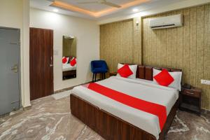 um quarto com uma cama grande e uma cadeira azul em OYO Flagship Hotel Z em Jaipur