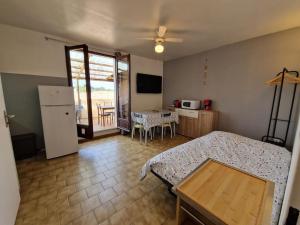 een kamer met een bed en een keuken met een tafel bij Agréable Appartement in La Londe-les-Maures
