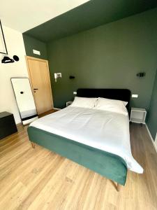 a large bed in a bedroom with a green wall at Mavi Rooms in Castel di Sangro