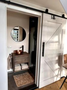 uma porta de garagem branca num quarto com um espelho em Tiny house of Picasso em Warmenhuizen