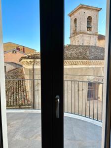 a door to a balcony with a view of a church at Mavi Rooms in Castel di Sangro